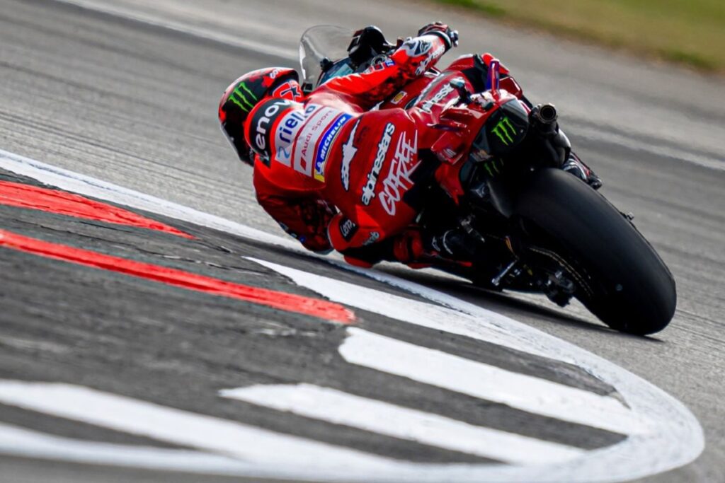 Francesco Bagnaia na motociklu Ducati Desmosedici GP25 v nagibu skozi ovinek na dirkališču, med vikendom MotoGP.